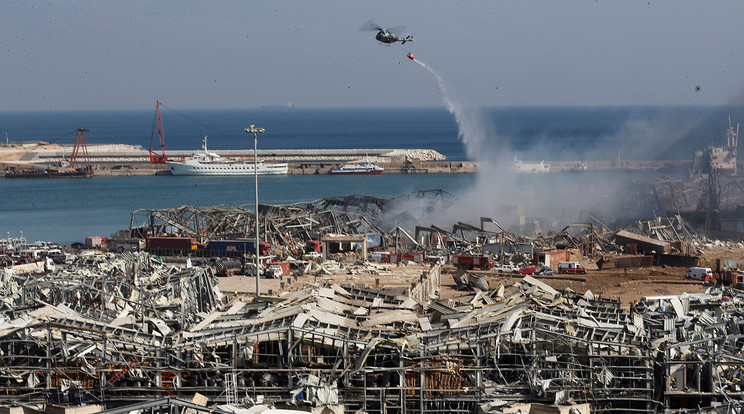 A fotón: Katonai helikopterről locsolják a még füstölgő romokat a bejrúti kikötőben történt előző napi hatalmas robbanást követően 2020. augusztus 5-én. A detonáció következtében legkevesebb száz ember életét vesztette, több mint négyezren megsebesültek / Fotó: MTI/AP/Huszein Malla