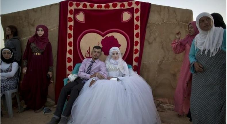 Ahmad Khalid and his bride, Fatheya Mohammed, both 21, sit in front of his family's tent during their wedding ceremony in an informal tent settlement on the outskirts of Mafraq, Jordan, near the Syrian border, on Aug. 7. 