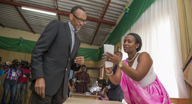 Rwanda President Paul Kagame is guided by polling assistants as he votes in Rwanda's capital Kigali December 18, 2015, during a referendum as Rwandans vote to amend its Constitution to allow the President to seek a third term. REUTERS/Village Urugwiro/Handout via Reuters