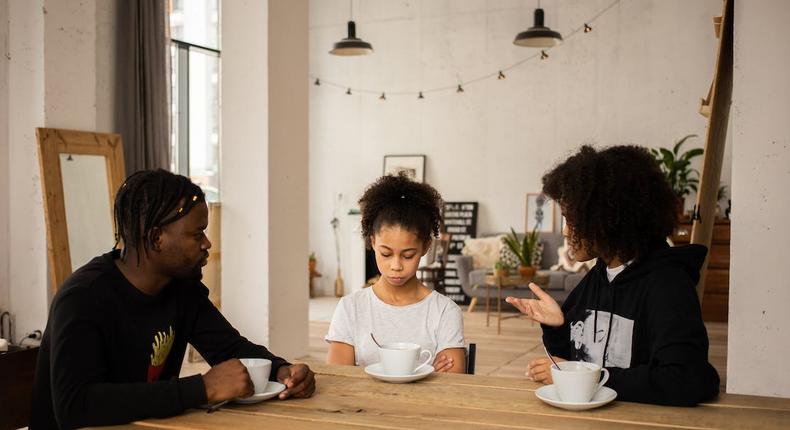Black parents lecturing upset daughter at table [Credit: Monstera Production]