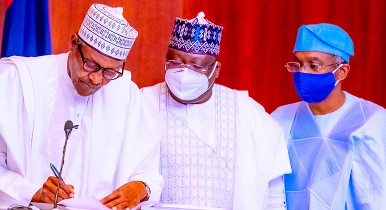 Former President Muhammadu Buhari with former Senate President Ahmad Lawan and former Speaker Femi Gbajabiamila at the signing of the Electoral Act Amendment Bill in Abuja on February 25, 2022