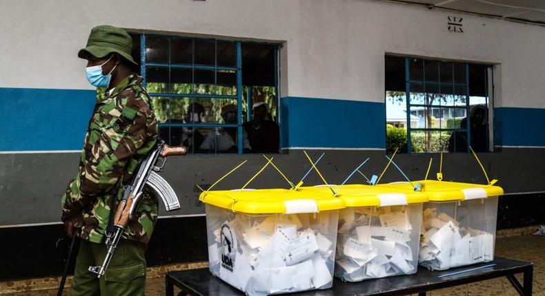 NAKURU, RIFT VALLEY, KENYA - 2022/04/14: A police officer walks past sealed ballot boxes during United Democratic Alliance party primaries. United Democratic Alliance (UDA), a political party whose flag bearer is William Ruto, The Deputy President of Kenya, conducted its nationwide primaries on April 14, 2022 in preparation for August general elections. (Photo by James Wakibia/SOPA Images/LightRocket via Getty Images)