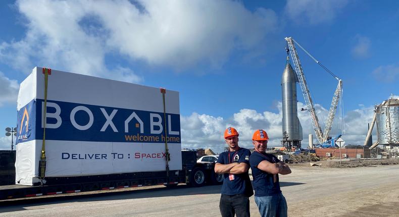 Boxabl co-founders Paolo and Galiano Tiramani with one of their startup's tiny homes on the bed of a truck at a SpaceX site.Boxabl