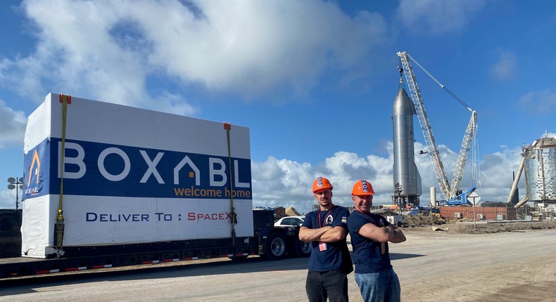 Boxabl co-founders Paolo and Galiano Tiramani with one of their startup's tiny homes on the bed of a truck at a SpaceX site.Boxabl