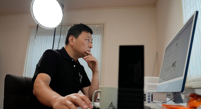 Wang Zhi'an checks his website during an interview with the Associated Press in Tokyo on October 5, 2022.Eugene Hoshiko/AP Photo