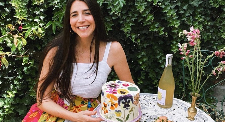 Loria Stern, the owner of Eat Your Flowers, next to her bakery's signature edible flower-pressed cake.Courtesy of Loria Stern