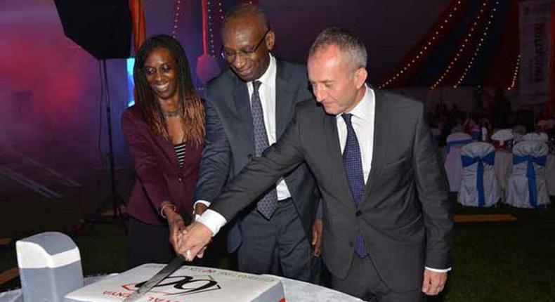 Momar Nguer (centre), Total's Africa and Middle East Senior Vice President, former Total Kenya managing director Ms Ada Eze (left) and Total Kenya chairman Jean-Christian Bergeron cut a cake to celebrate the firms 60th anniversary. 