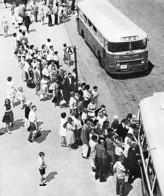 Zatłoczony przystanek autobusowy w stolicy, lata 60. (domena publiczna).