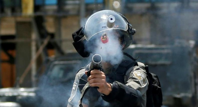 An Israeli border guard fires tear gas at Palestinian protesters near the Jewish settlement of Beit El in the occupied West Bank on July 24, 2017