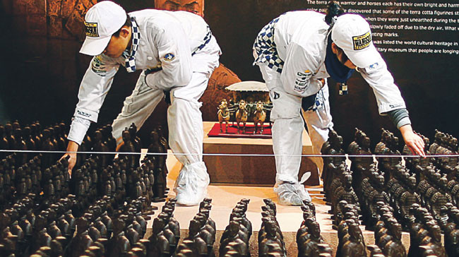 Chińscy robotnicy pracują nad czekoladową repliką słynnej armii z terakoty, Pekin 14 stycznia 2010 r. Fot. AFP