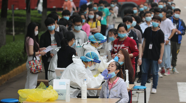 Védőöltözetet viselő egészségügyi dolgozók vizsgálati mintát vesznek koronavírustesztre gyári munkásoktól a közép-kínai Vuhanban 2020. május 15-én. / Fotó: MTI/EPA/Featurechina/Li Ke