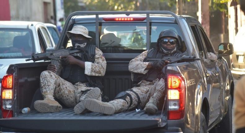 Haitian police stand guard outside a radio station after the arrest there of former coup leader Guy Philippe, long wanted by US authorities on drug trafficking charges