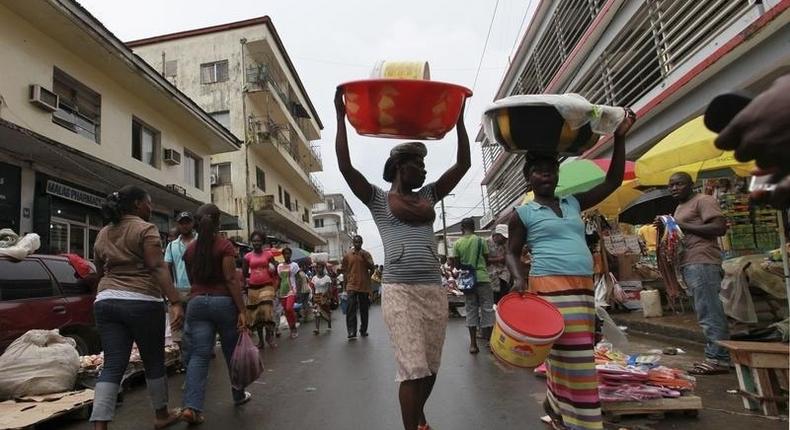 People walk along a street market in Monrovia October 13, 2011. 