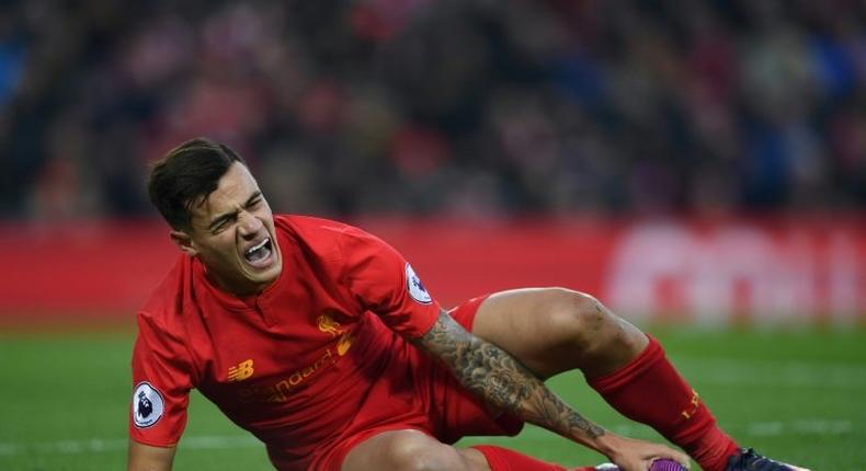 Liverpool's midfielder Philippe Coutinho holds his foot as he lies on the pitch injured during the English Premier League football match between Liverpool and Sunderland on November 26, 2016