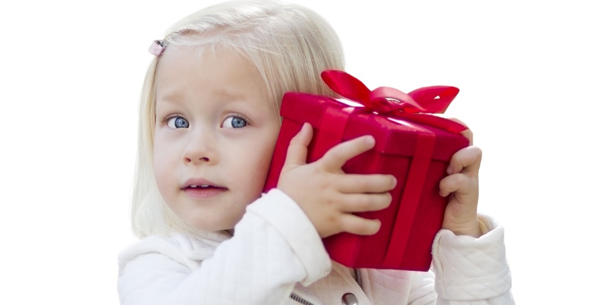 Happy Baby Girl Holding Red Christmas Gift Isolated on White Background.