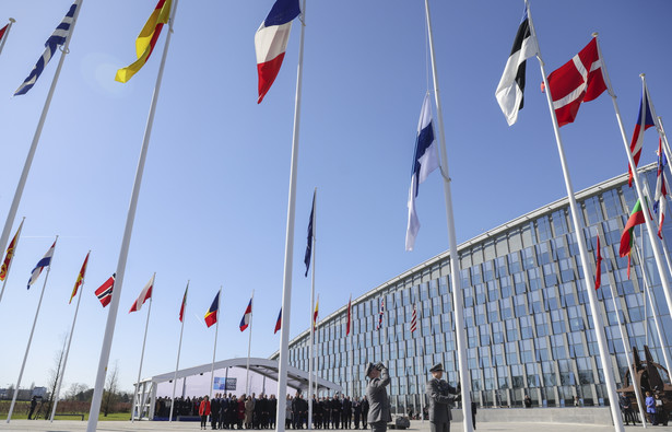 Flaga Finlandii wciągana na maszt przed kwaterą główną NATO w Brukseli
