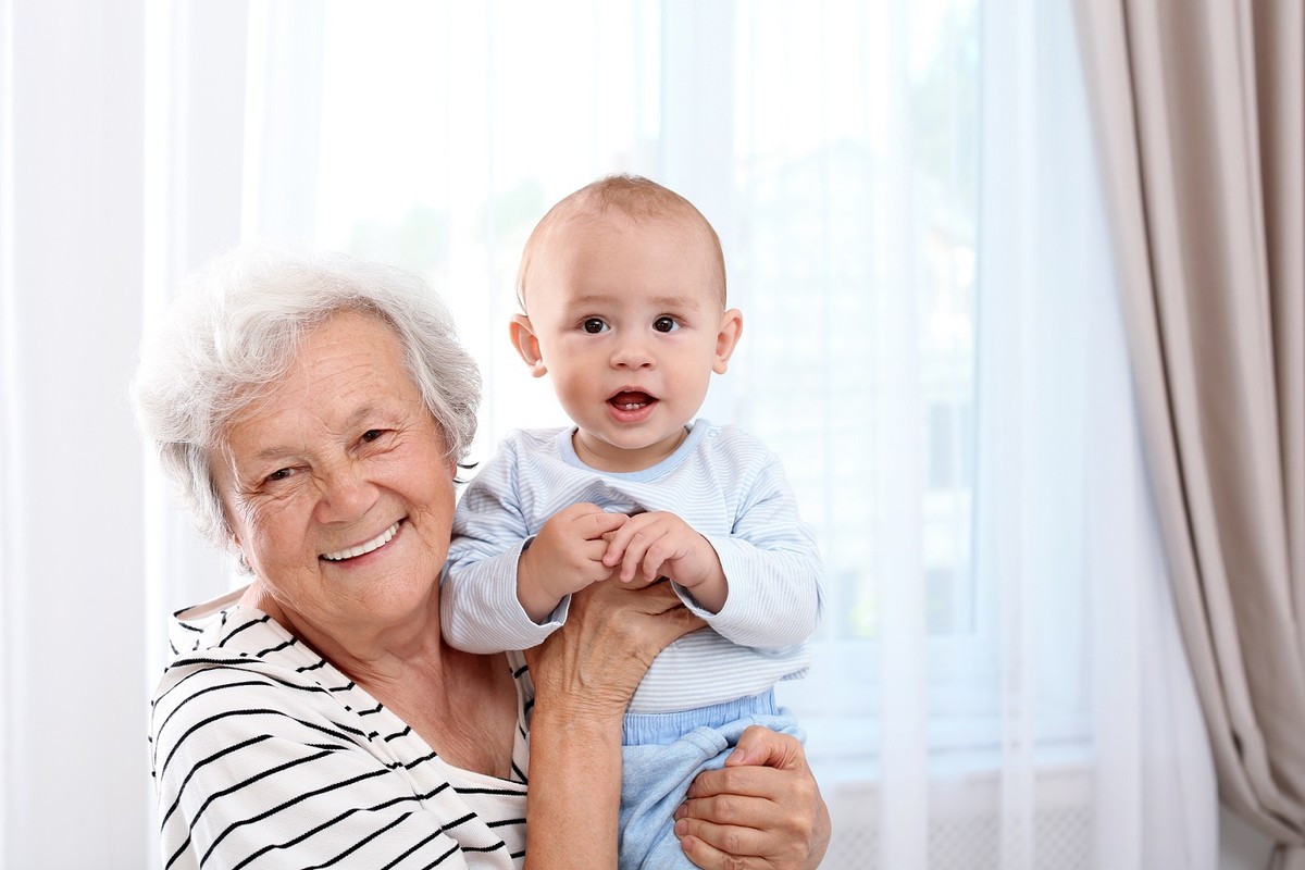 babcia trzyma uśmiechnięte dziecko