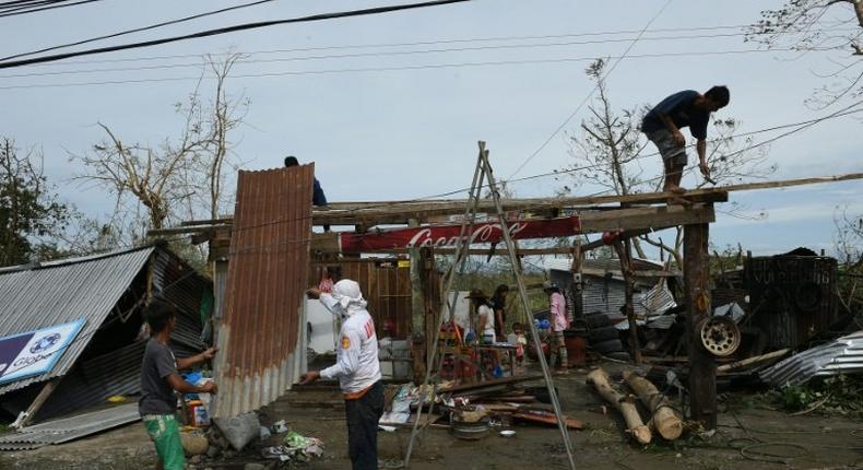 A family fix the roof of their house, damaged at the height of typhoon Haima, in Ilagan town, Isabela province, north of Manila, on October 20, 2016