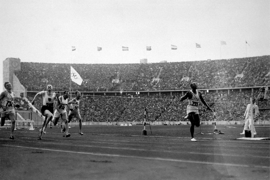 Jessie Owens wygrywa sprint na 100 metrów na igrzyskach w Berlinie w 1936 roku. Na mecie widać taśmę