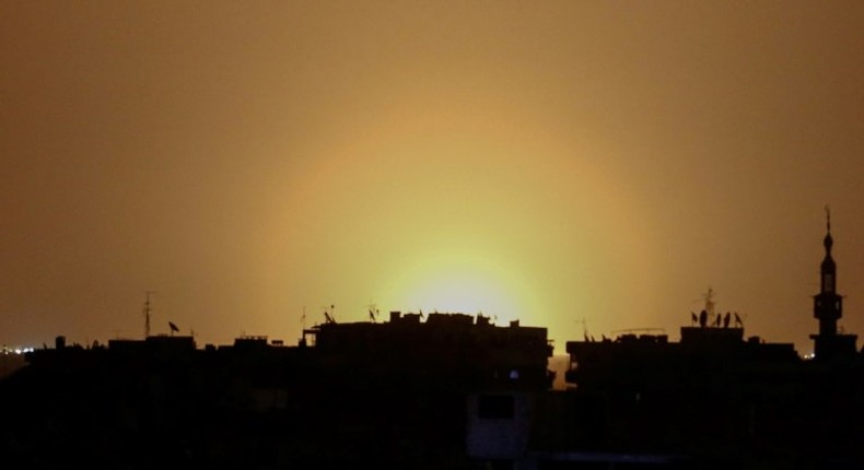 A photo taken from the rebel-held town of Douma shows flames rising in the distance which are believed to be coming from Damascus International Airport following an explosion early in the morning of April 27, 2017