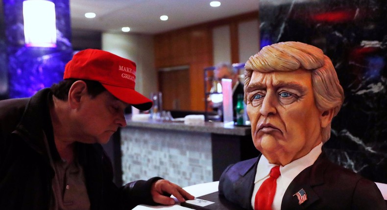 A man checks out a Trump cake ahead of the rally for Republican U.S. presidential nominee Donald Trump in New York City, New York, U.S. November 8, 2016.