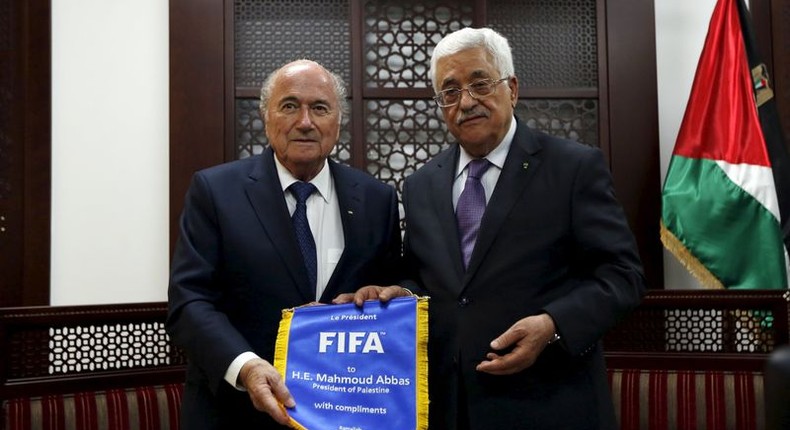 Palestinian President Mahmoud Abbas (R) receives a gift from FIFA chief Sepp Blatter during their meeting in the West Bank city of Ramallah May 20, 2015.   REUTERS/Mohamad Torokman