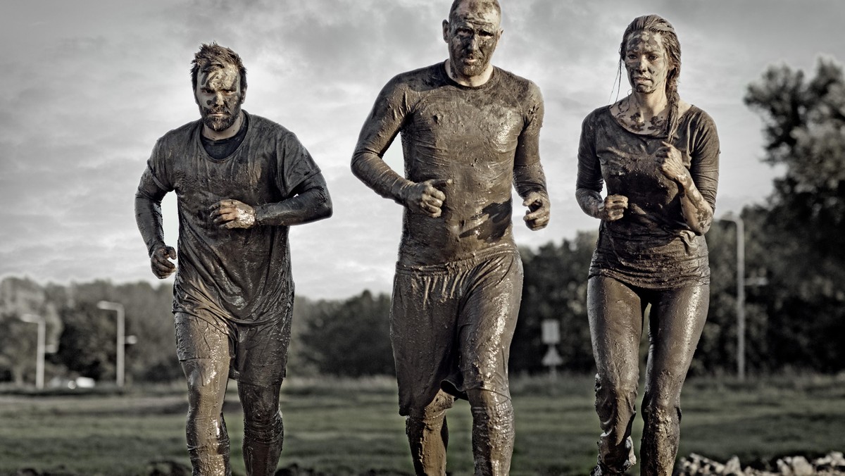 group of people jogging in mud