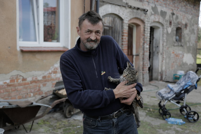 Mężczyzna trzyma kota na ramieniu