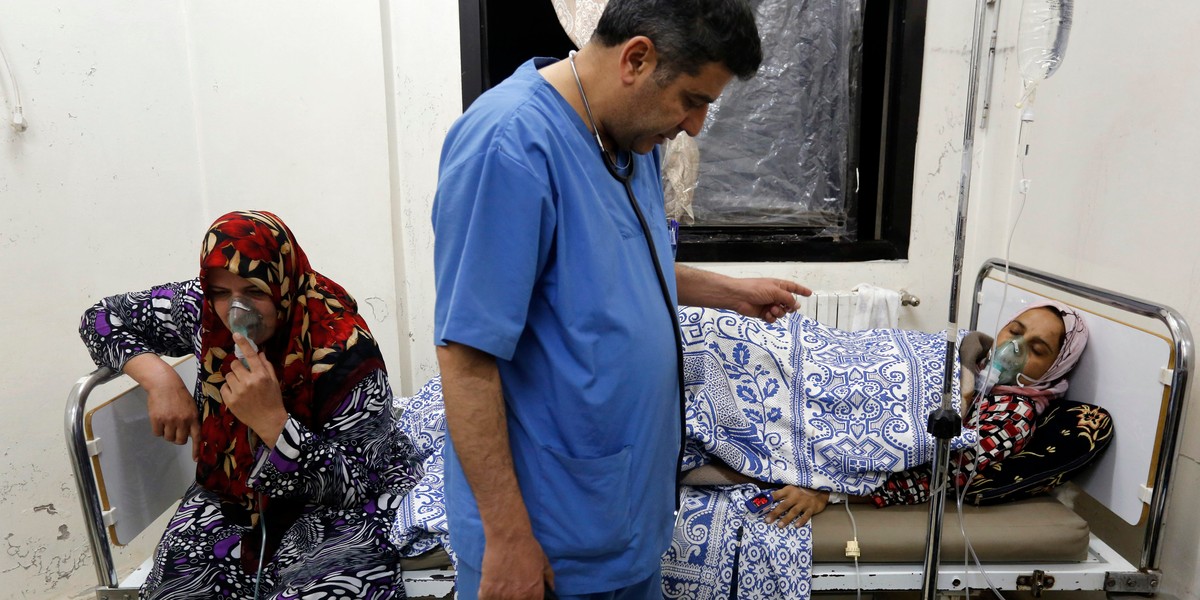 Women, affected by what activists say was a gas attack, receive treatment inside a makeshift hospital in Kfar Zeita village in the central province of Hama on May 22, 2014.