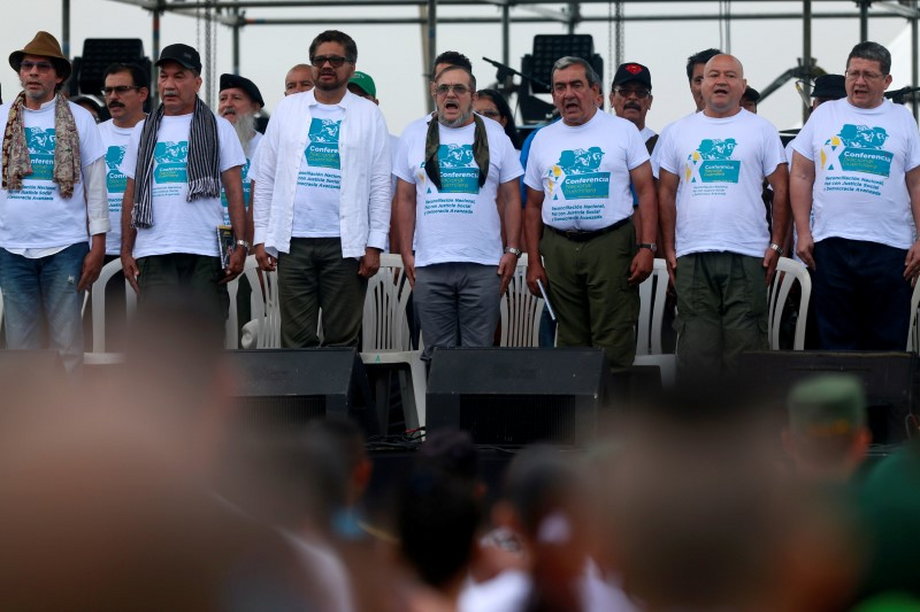 FARC rebel leader Rodrigo Londono, better known by nom de guerre Timochenko, center, and other leaders sing the anthem at the camp where they are preparing for ratifying a peace deal with the Colombian government, near El Diamante in Yari Plains.