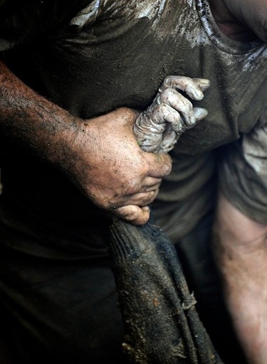 Rescue personnel recover a corpse in San Antonio de Escazu in the outskirts of San Jose after a landslide hit the village