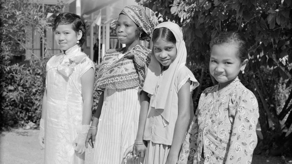 Zdjęcia autorstwa Willema van de Polla pochodzą z serii "Antyle Holenderskie i Surinam podczas królewskiej wizyty królowej Juliany i księcia Bernharda w 1955 roku" z holenderskiego Nationaal Archief; Dzieci z różnych grup ludności (chińskiej, kreolskiej, hinduskiej, jawajskiej)