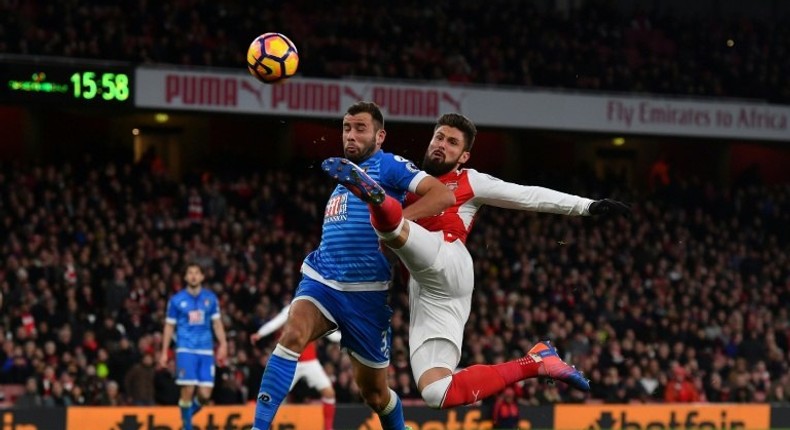 Arsenal's Olivier Giroud (R) has shot blocked by Bournemouth's Steve Cook during the match in London on November 27, 2016