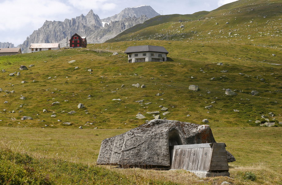 Zakamuflowana armata widoczna przed bunkrem karabinu maszynowego byłej szwajcarskiej fortecy artyleryjskiej Fuchsegg obok drogi górskiej Furka w pobliżu wioski Realp. ZForteca Fuchsegg, położona w centralnej Alpy Szwajcarskie została zbudowana w 1943 r. i służyły do ​​​​1993 r. Zdjęcie zrobione 6 sierpnia 2015 r.