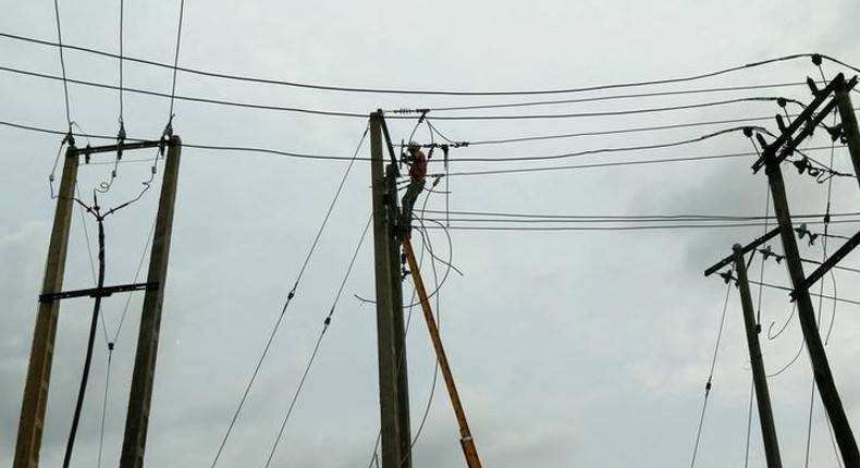 A power labourer fixes electric cables on a pole in Ojodu district in Nigeria's commercial capital Lagos September 29, 2016.REUTERS/Akintunde Akinleye.