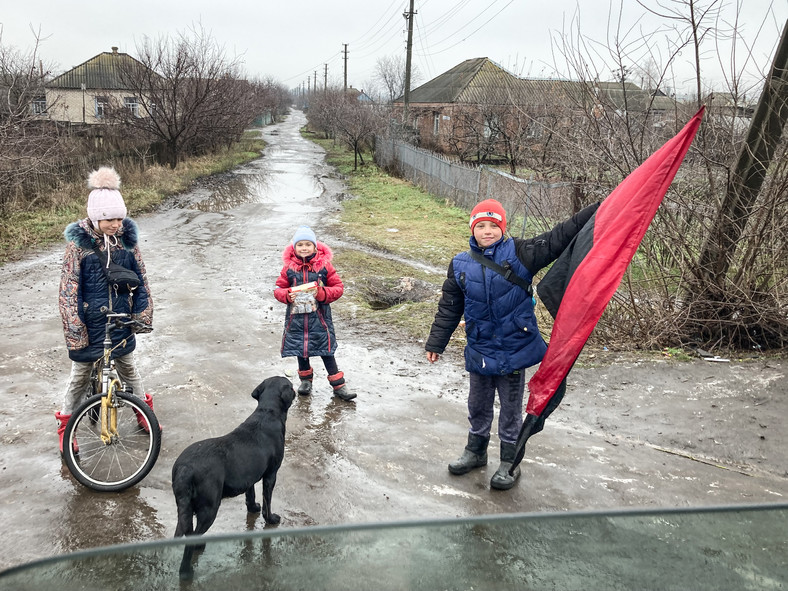 Dzieci z Izium, witające podróżnych tzw. banderowską flagą