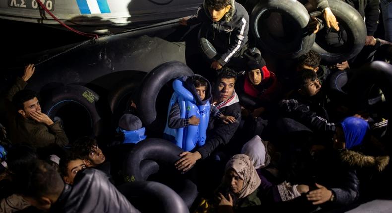Migrants and refugees are seen on an inflatable boat during a rescue operation near the Greek island from Samos in November 2019