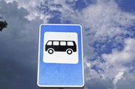 Bus stop road sign on background of blue sky.