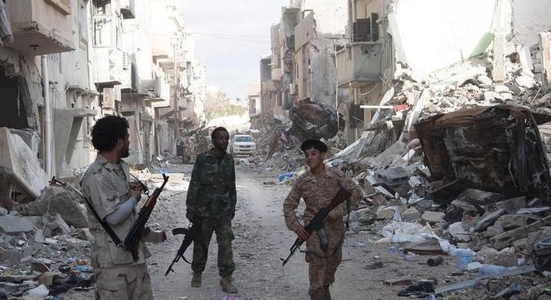 Members of Libyan pro-government forces, backed by the locals, walk with weapons during clashes in the streets with Shura Council of Libyan Revolutionaries, an alliance of former anti-Gaddafi rebels who have joined forces with Islamist group Ansar al-Sharia, in Benghazi April 1, 2015. REUTERS/Stringer