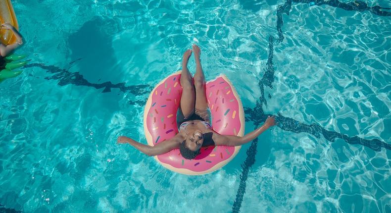 Woman on a pink swim ring [Photo: Kindel Media]