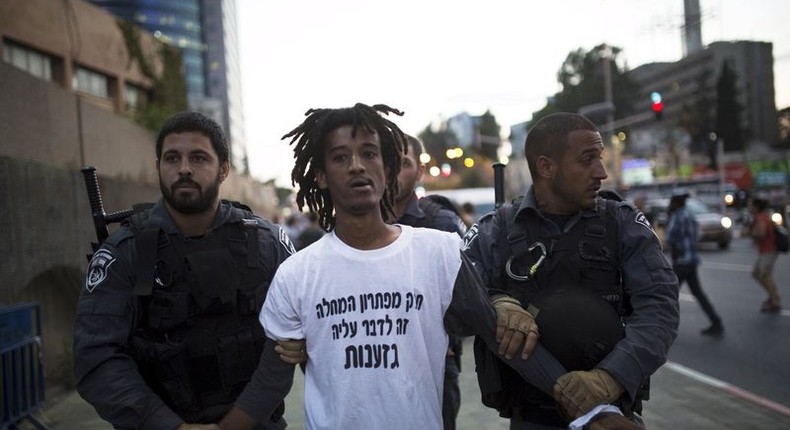 Israeli policemen detain a protestor during an anti-racism protest in Tel Aviv June 3, 2015. REUTERS/Amir Cohen