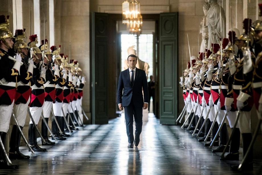 French President Emmanuel Macron walks through the Galerie des Bustes (Busts Gallery) to access the 