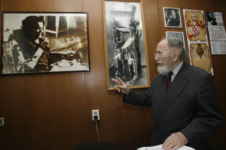 Prof. dr Vukobratović pokazuje model egzoskeleta i sliku na kojoj je prikazana Olivera Andrić sa ortotičkom rukom