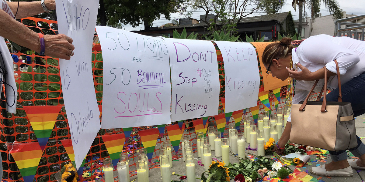 People tend to a memorial at the Christopher Street West presentation of the Los Angeles LGBT Pride Parade in West Hollywood, California, U.S. June 12, 2016 in honor of the victims of the deadly attacks at a gay night club in Orlando, Florida earlier in the morning.