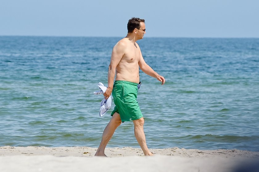 Radosław Sikorski na plaży ćwiczy brzuszki 