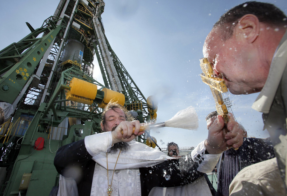 An Orthodox priest blesses specialists and the Soyuz TMA-01M spacecraft during a ceremony at the launch pad at Baikonur cosmodrome