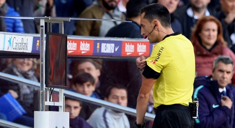 Spanish referee Sanchez Martinez checks the VAR screen before signaling a penalty kick against Real Madrid