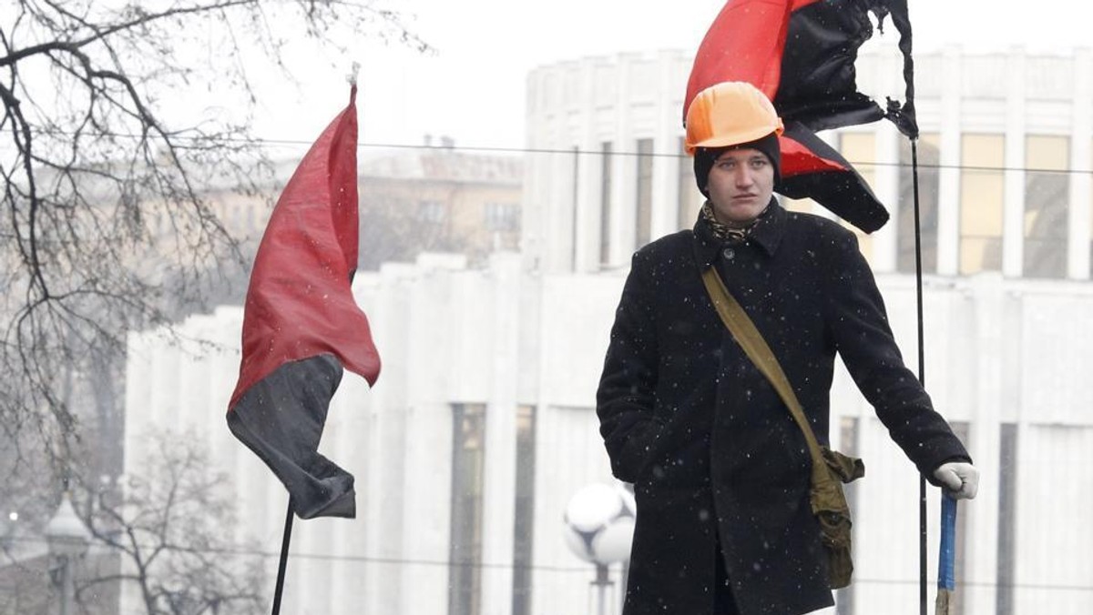 Jeden z demonstranów w Kijowie, w tle flagi kojarzone z zachodnioukraińskim nacjonalizmem. źródło: 