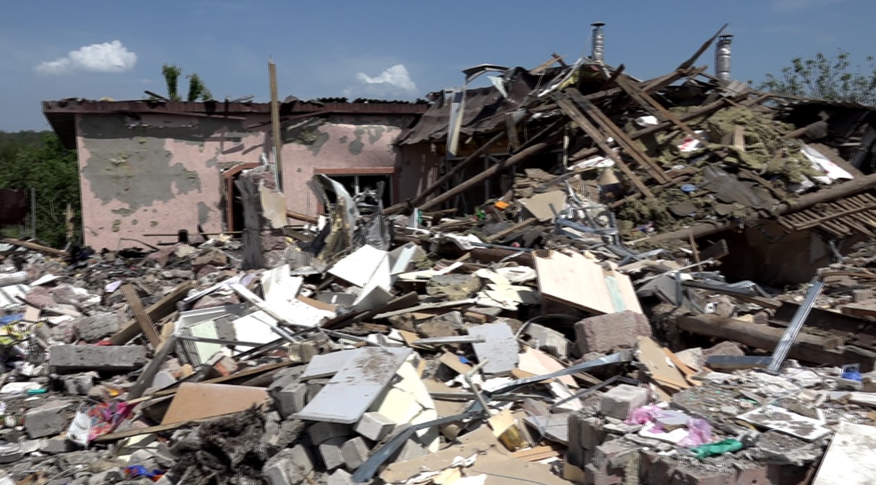 Lej po bombie, która wybuchła w Drużkiwce oraz ruiny domów. 