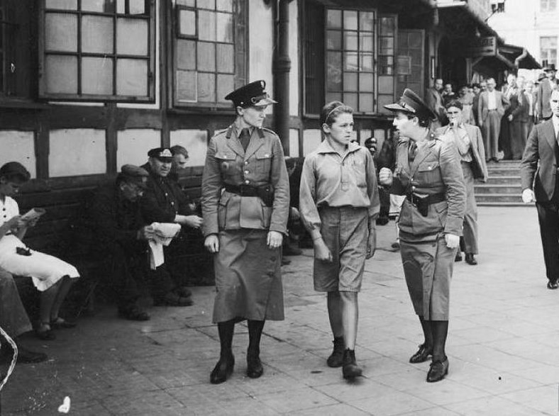 Policjantki prowadzą młodego kieszonkowca do izby zatrzymań ulicami Warszawy w roku 1939